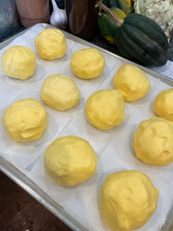 A tray that is full of 1/2 cup sized yellow butter balls.